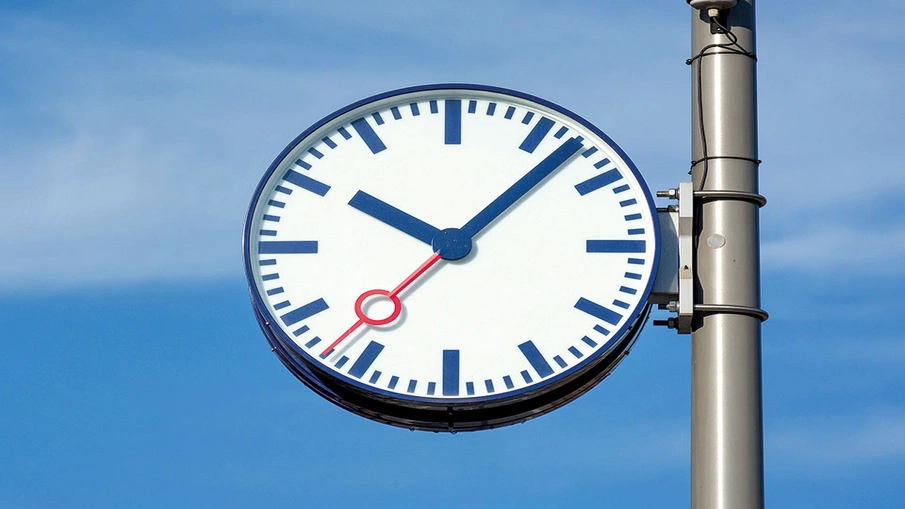 Eine Bahnhofsuhr vor blauem Himmel