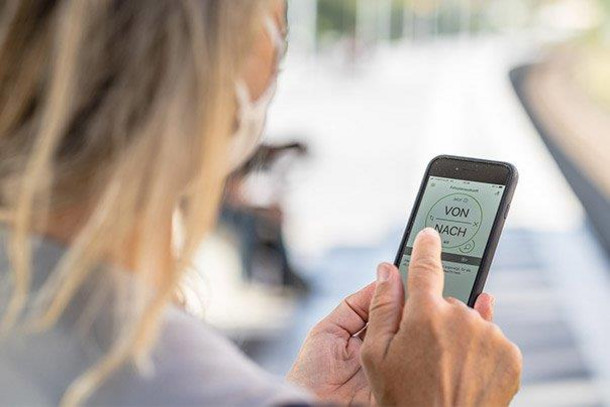 Eine Frau bedient die VRR-App auf ihrem Smartphone