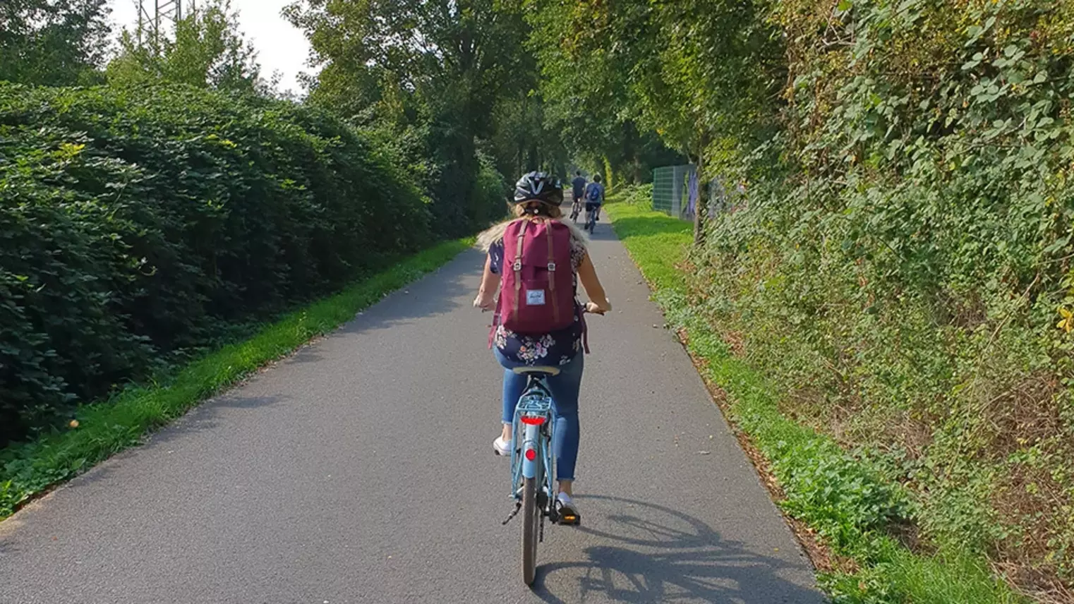 Eine Frau fährt mit ihrem Fahrrad über eine Bahntrasse