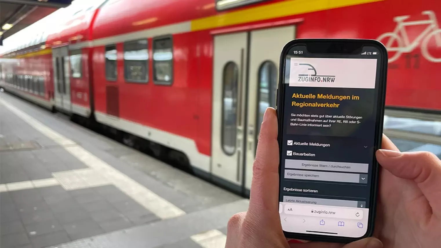 Ein Smartphone vor einem Zug 