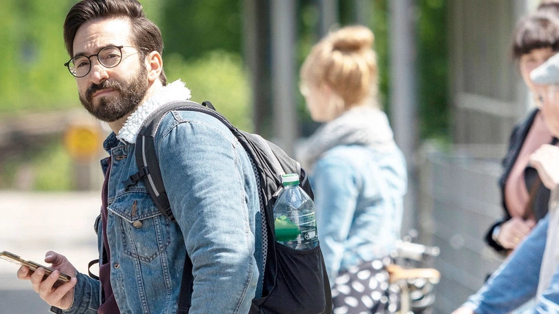 Ein Fahrgast hält am Bahnsteig nach dem Zug Ausschau