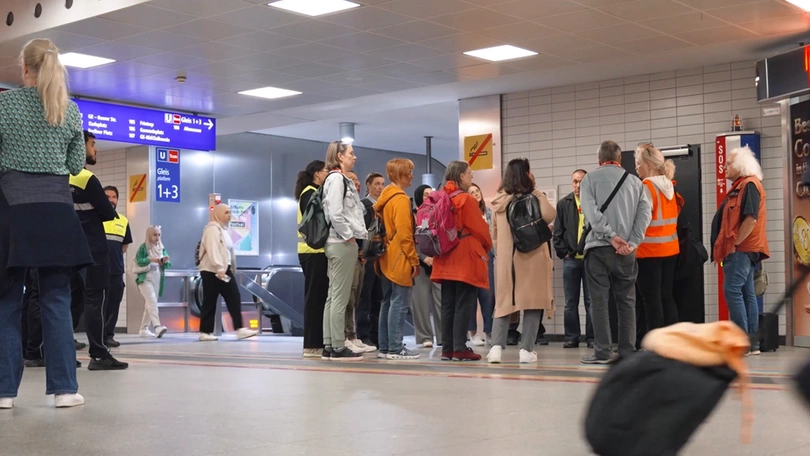 Eine Gruppe von Leuten steht am Bahnhof und lauscht einer Sicherheitsführung