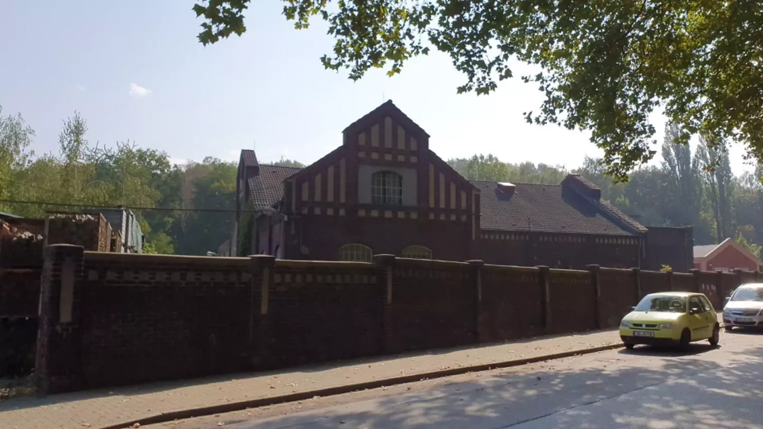 Ein schöner Altbau hinter einer Backsteinmauer