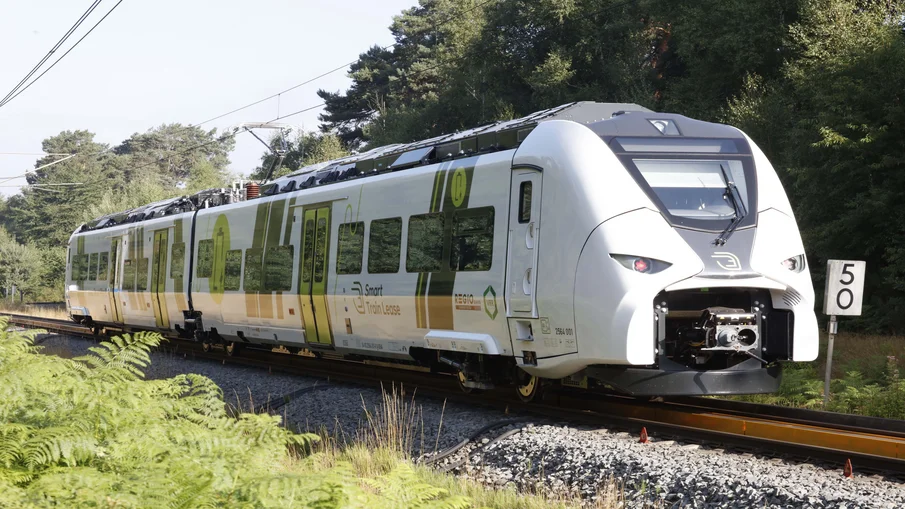 Ein Zug steht auf dem Gleis. Es ist der Zug des RE 47.