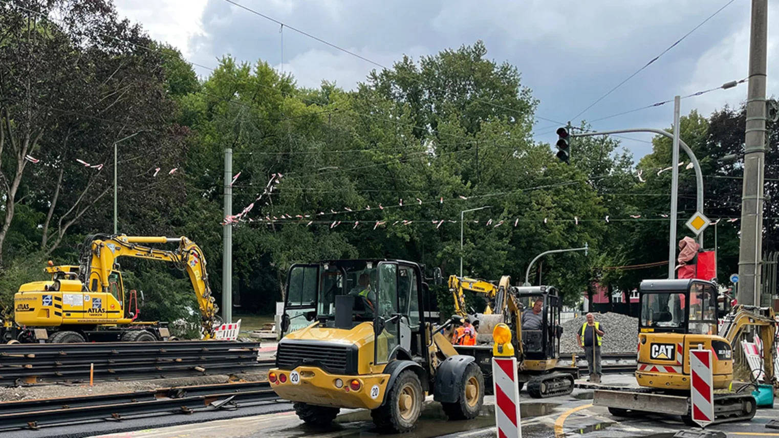Neubau Haltestelle Brückelstraße: Blick auf die Baustelle mit mehreren Bauarbeitern und Baumaschinen