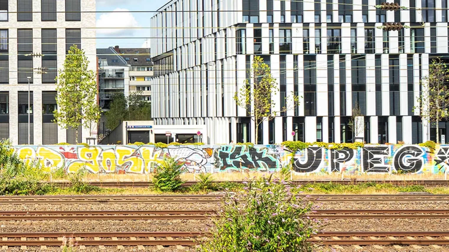 Eine Bahnstrecke entlang an Bürogebäuden