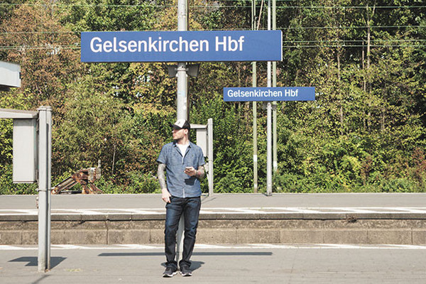 Ein Mann mit Smartphone steht am Gelsenkirchener Hauptbahnhof am Bahnsteig