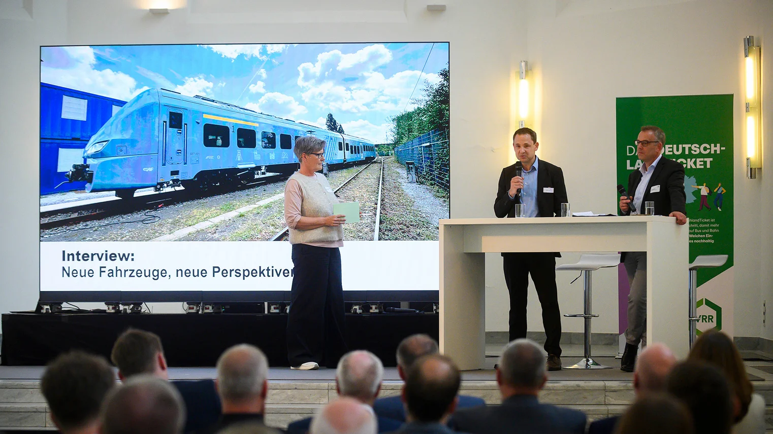 © VRR VRR-Niederrheinkonferenz 2026: Moderatorin Sabine Tkatzik, CAF-Geschäftsführer Marcus Brüning und Georg Seifert, VRR-Abteilungsleiter SPNV (v. l. n. r.)