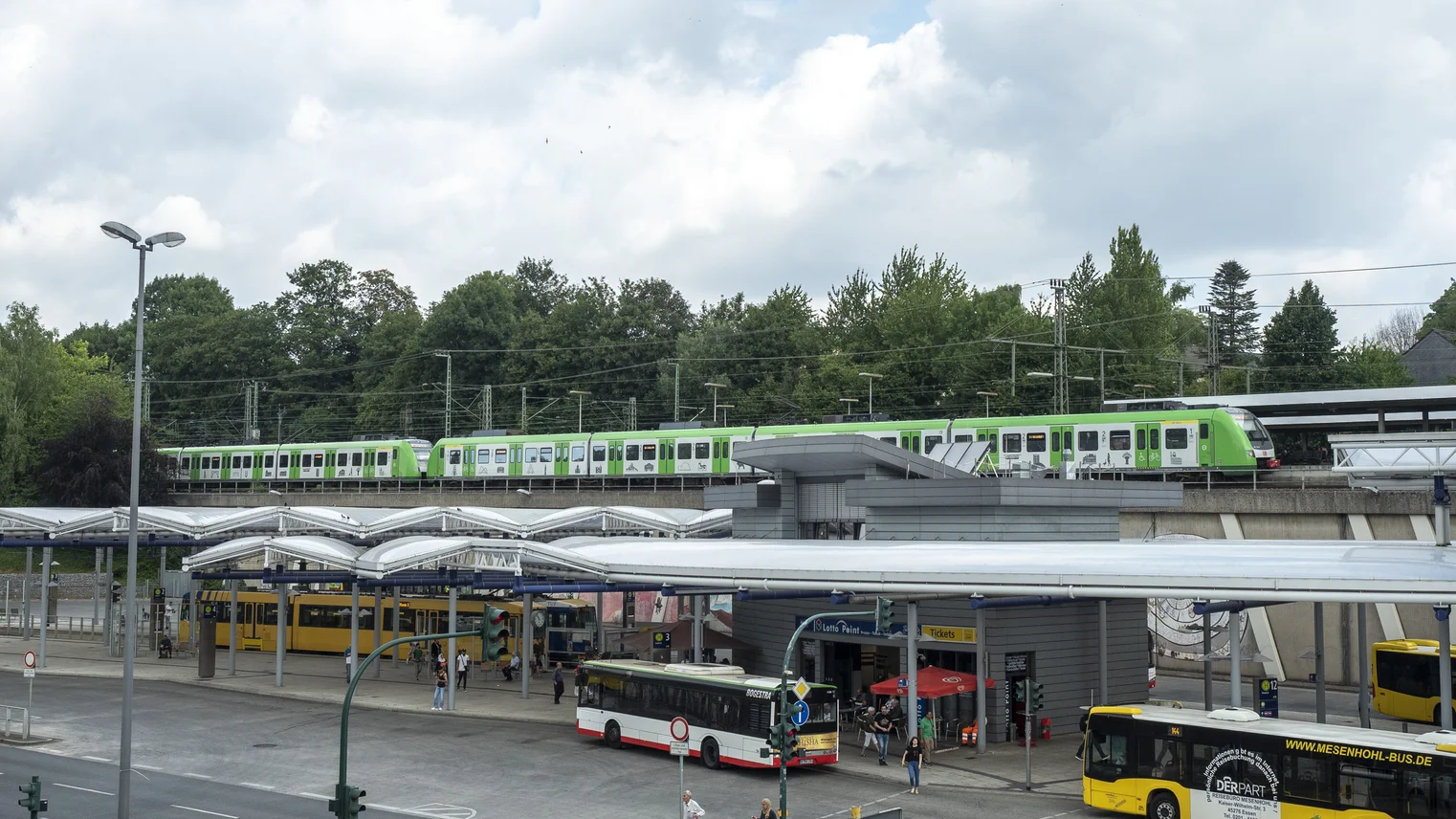 Eine Sbahn im Hintergrund, ein Busbahnhof im Vordergrund