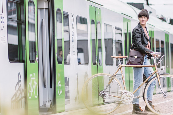 Eine Frau steigt aus einer grünen S-Bahn Rhein-Ruhr aus