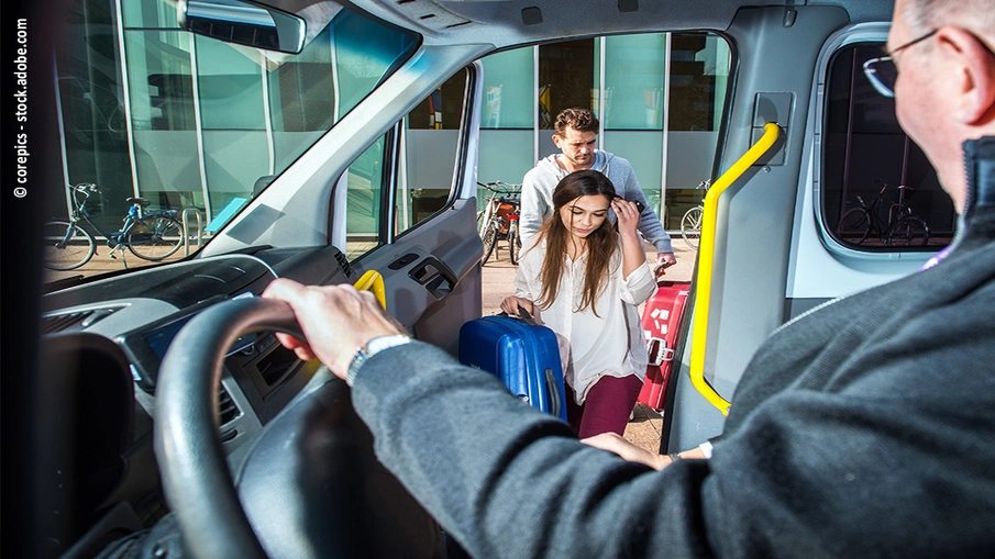 Eine Frau und ein Mann steigen beim Fahrer in einen Kleintransporter ein