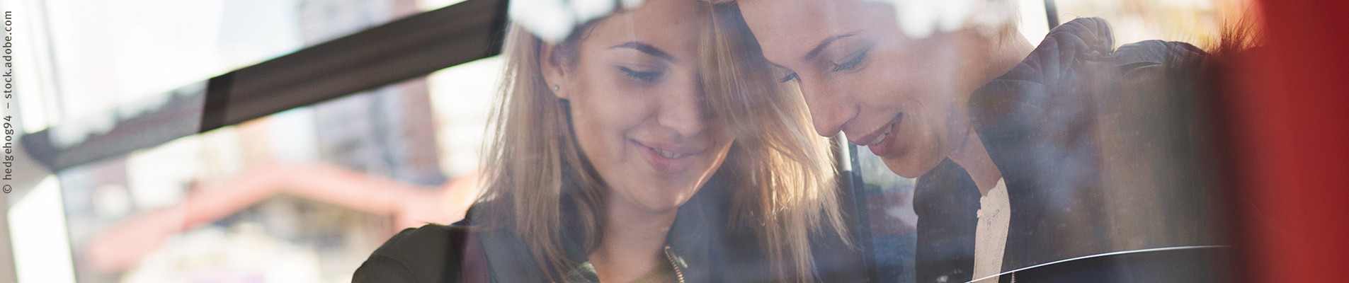 Zwei Frauen schauen auf ihr Smartphone
