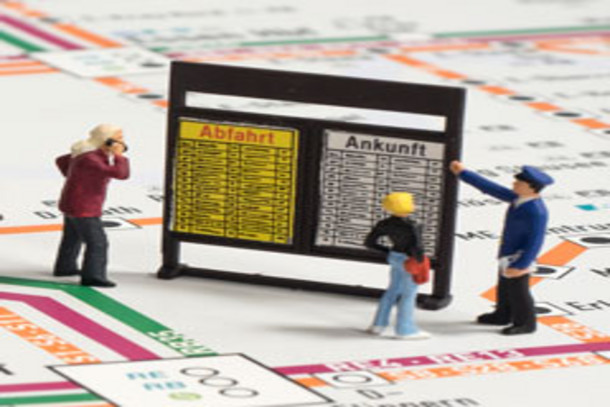 Miniaturfiguren gucken auf einen Fahrplan-Kasten
