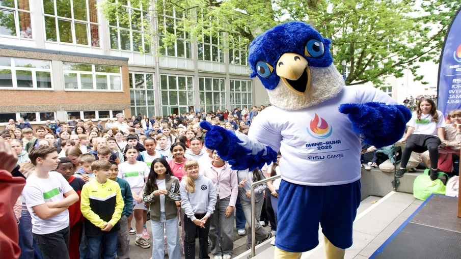 Das Maskottchen von FISU lächelt in die Kamera.