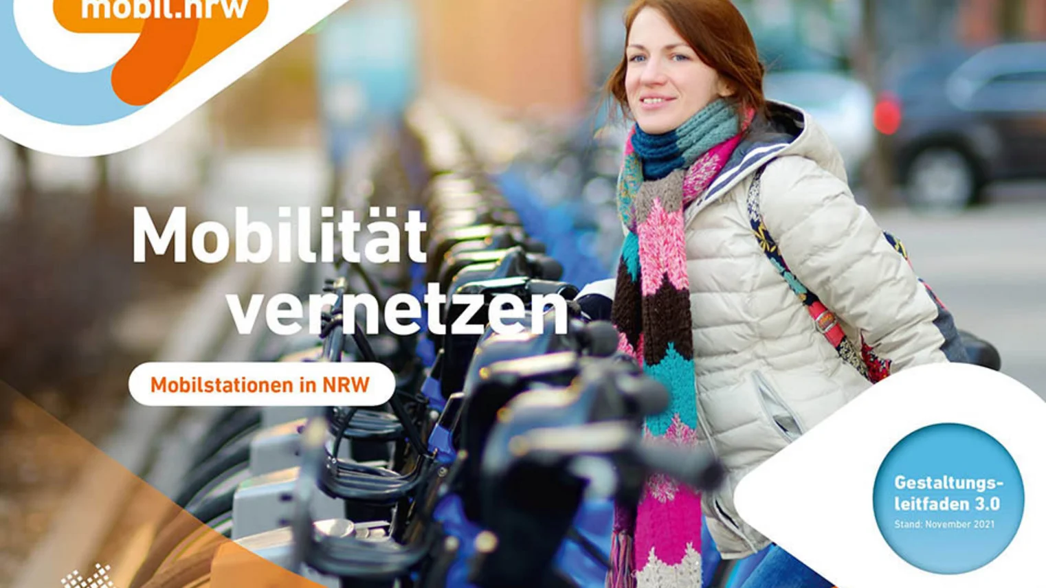 Eine Frau stellt ein Fahrrad an einer Mobilstation ab