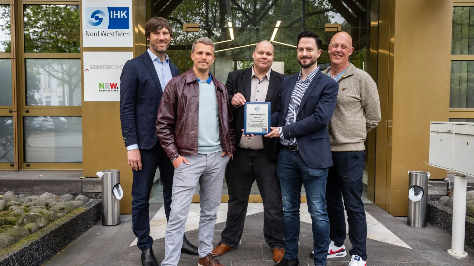 © Pöhnert / IHK Nord Westfalen Eine Gruppe von Männern zeigt einen Award als Auszeichnung in die Kamera