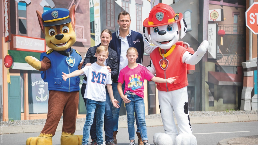 Eine Familie posiert für ein Foto mit den Figuren von PAW Patrol.