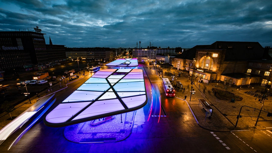 Der Busbahnhof in Mönchengladbach von oben fotografiert im abendlichen Betrieb.