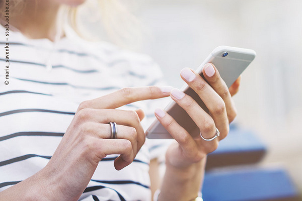 Eine Frau tippt auf ihrem Handy.