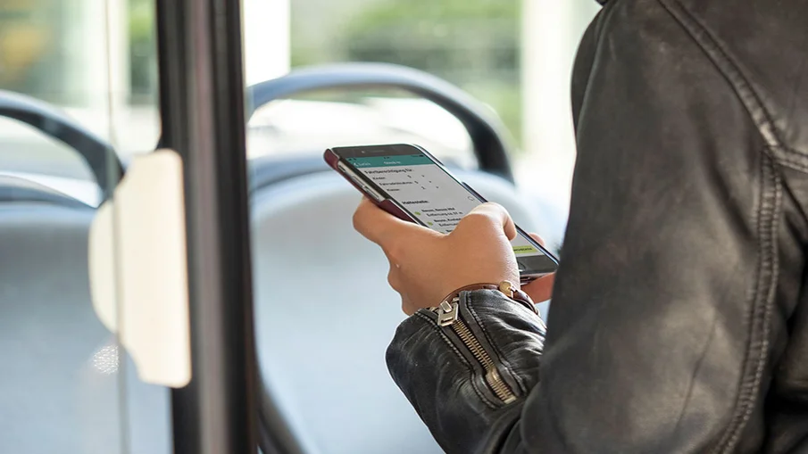 Eine Person schaut im Bus auf ihr Smartphone