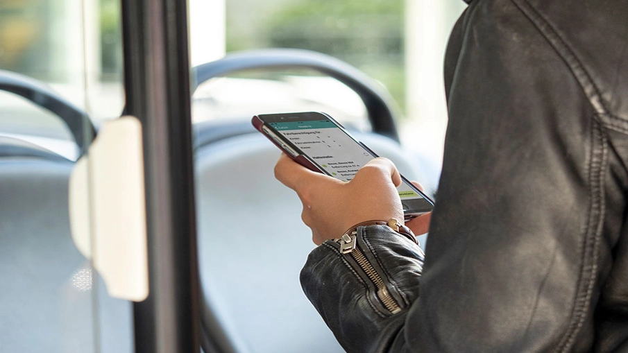Eine Person schaut im Bus auf ihr Smartphone