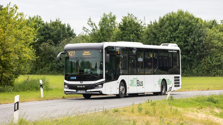 Ein X-Bus fährt über eine Landstraße.