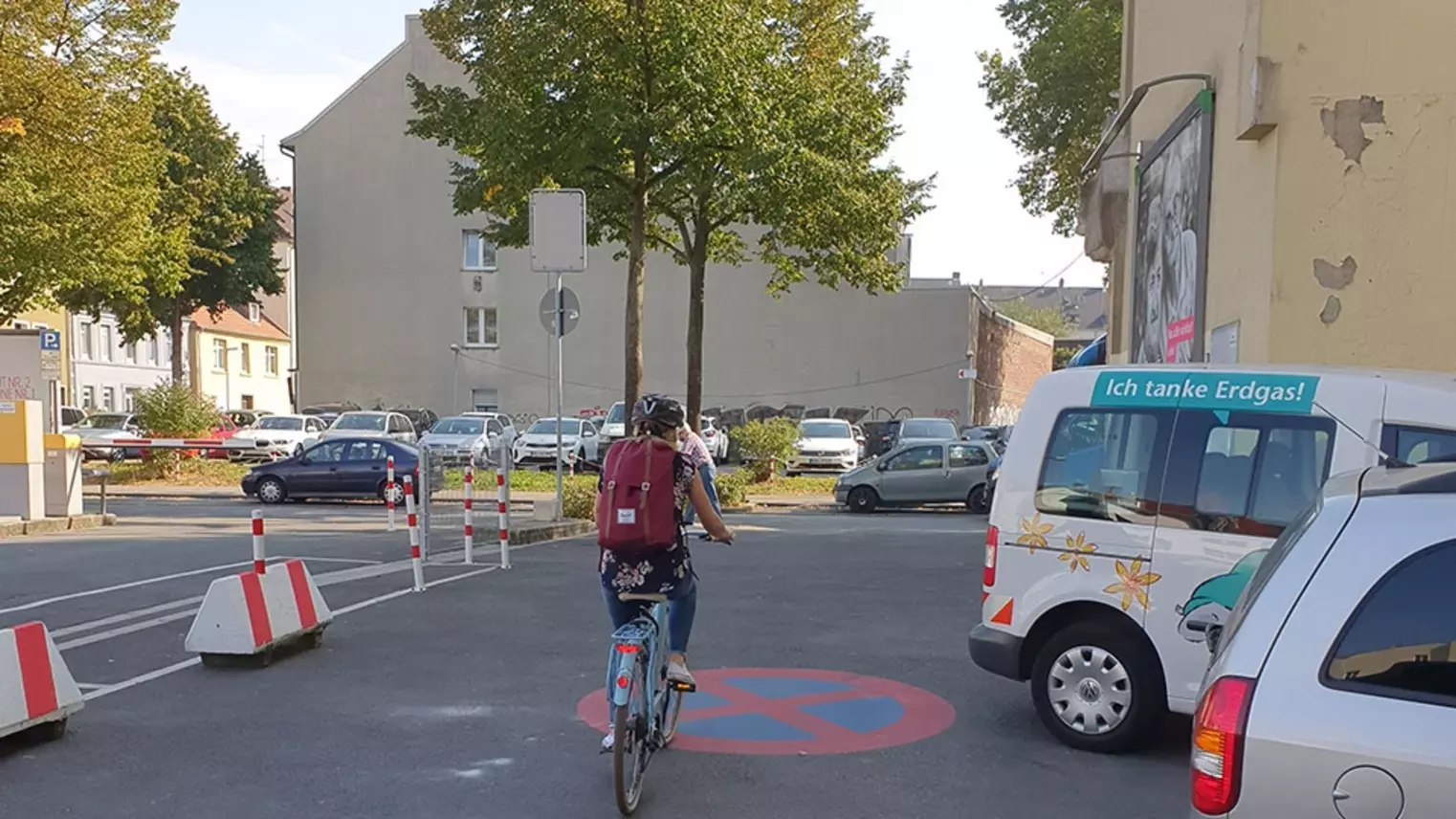 Eine Frau fährt auf ihrem Fahrrad über einen Parkplatz