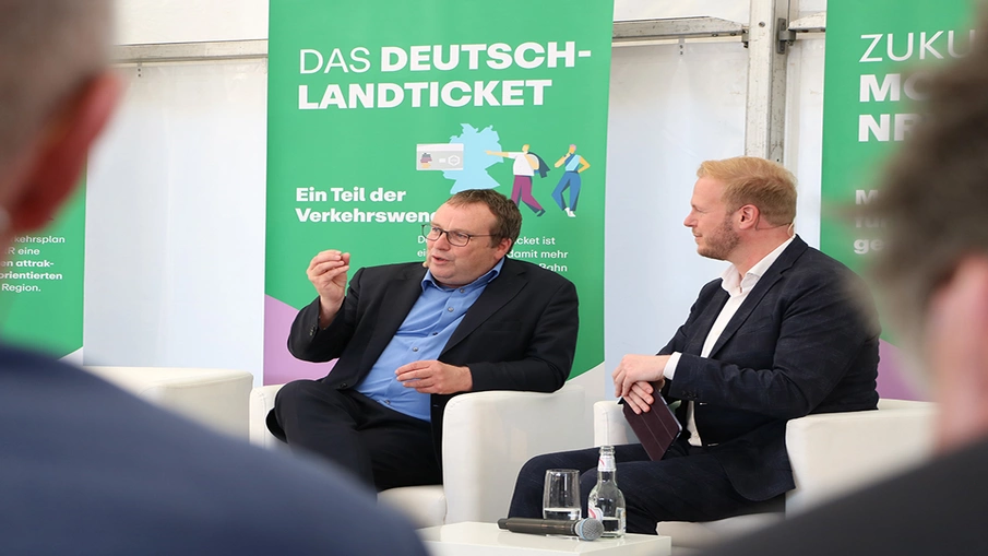 NRW-Verkehrsminister Oliver Krischer im Gespräch mit Moderator Tobias Häusler bei der zentralen Eröffnungsfeier zum Tag der Schiene 2024 in Mettmann