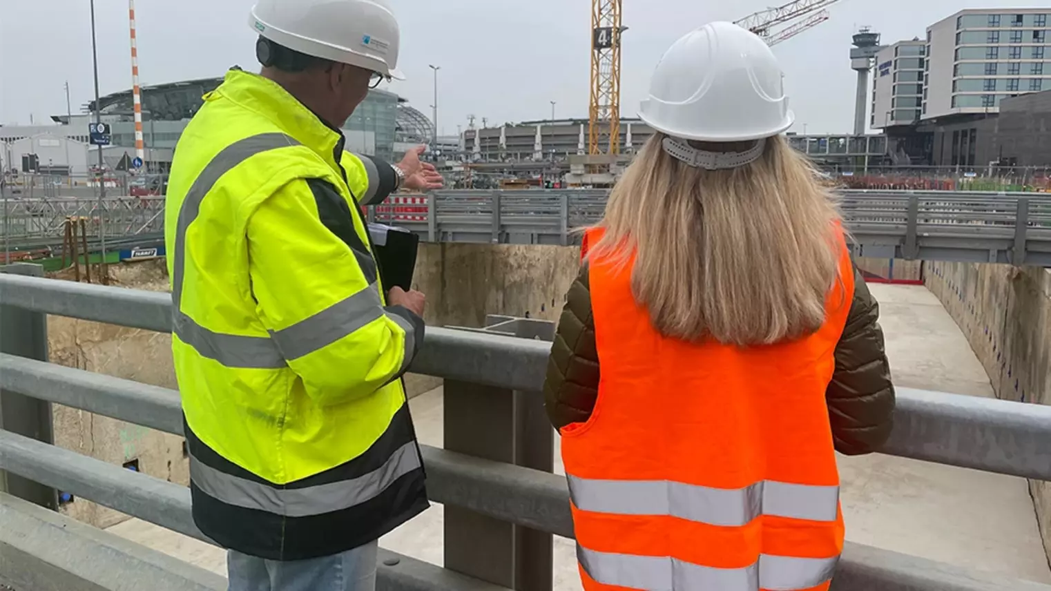 Zwei Menschen schauen auf die Baugrube
