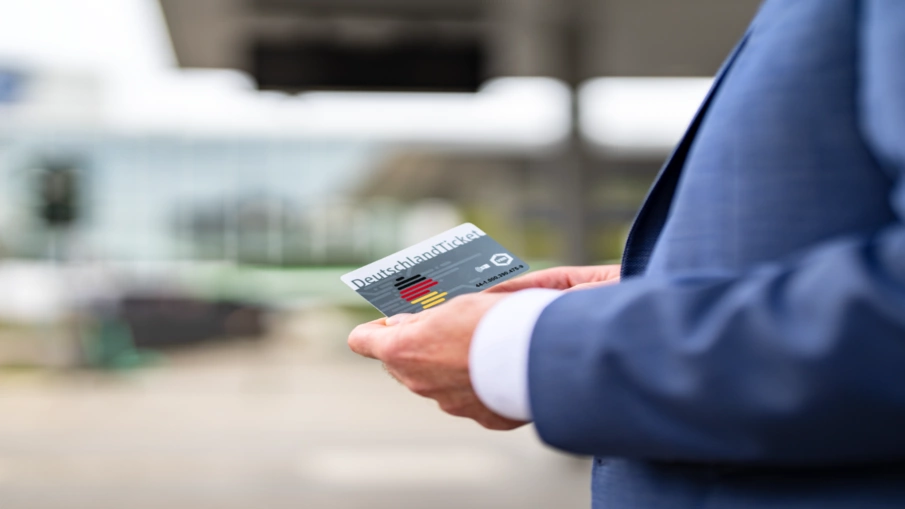 Das DeutschlandTicket in der Hand eines Mannes