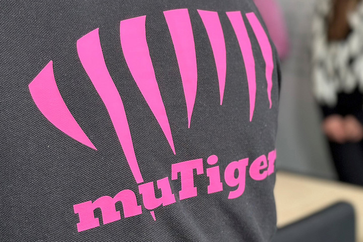 Detailansicht einer Person von hinten, im Bild zu sehen ist ein Shirt mit dem Logo der muTiger-Stiftung