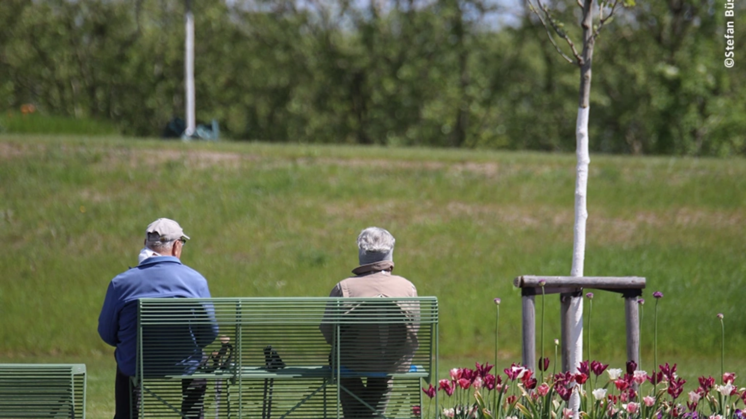 Mann und Frau sitzen auf einer Bank der Landesgartenschau