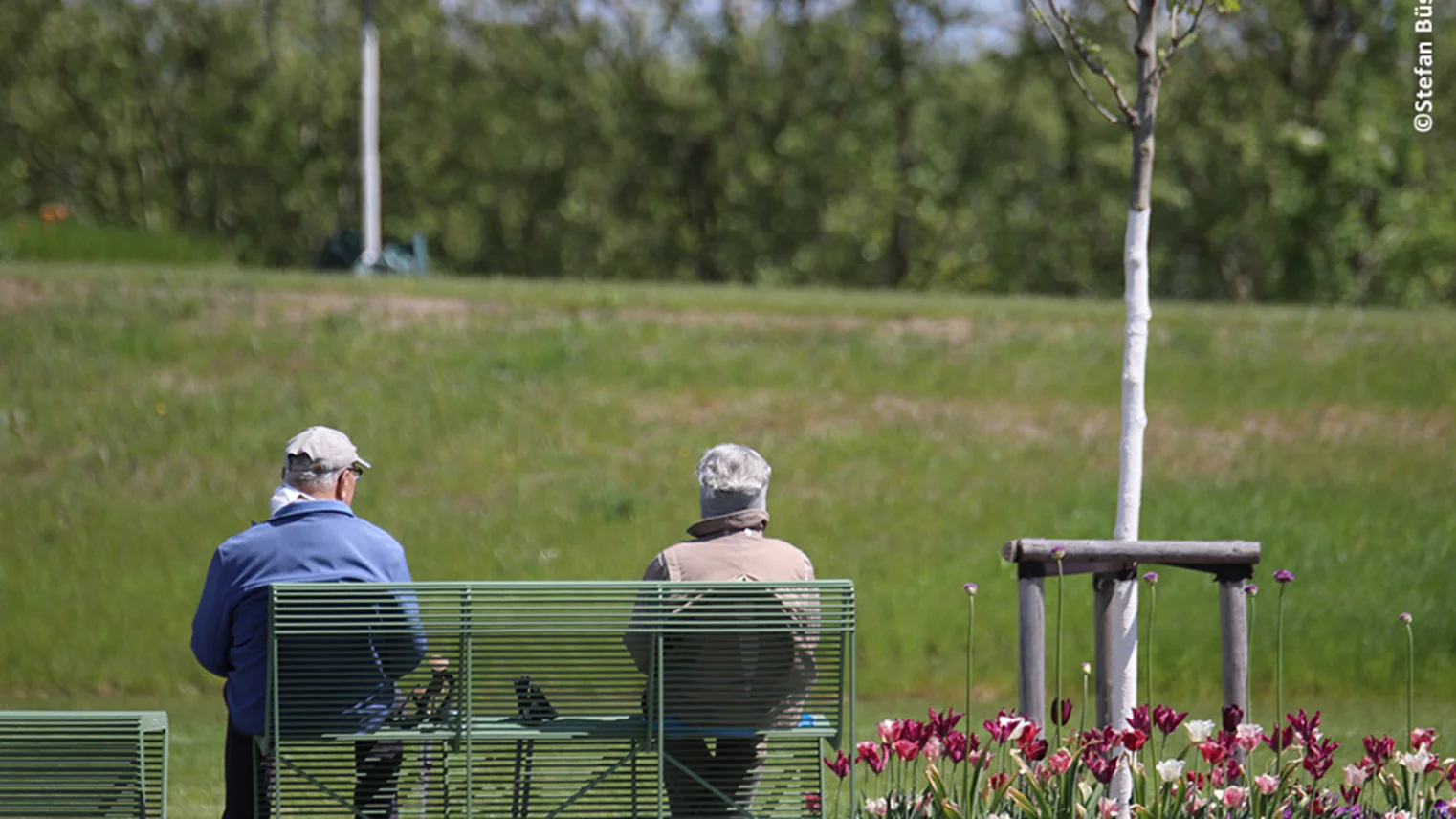 Mann und Frau sitzen auf einer Bank der Landesgartenschau