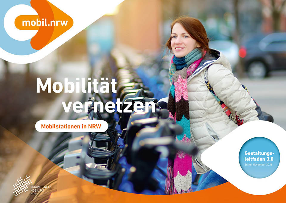 Eine Frau stellt ein Fahrrad an einer Mobilstation ab