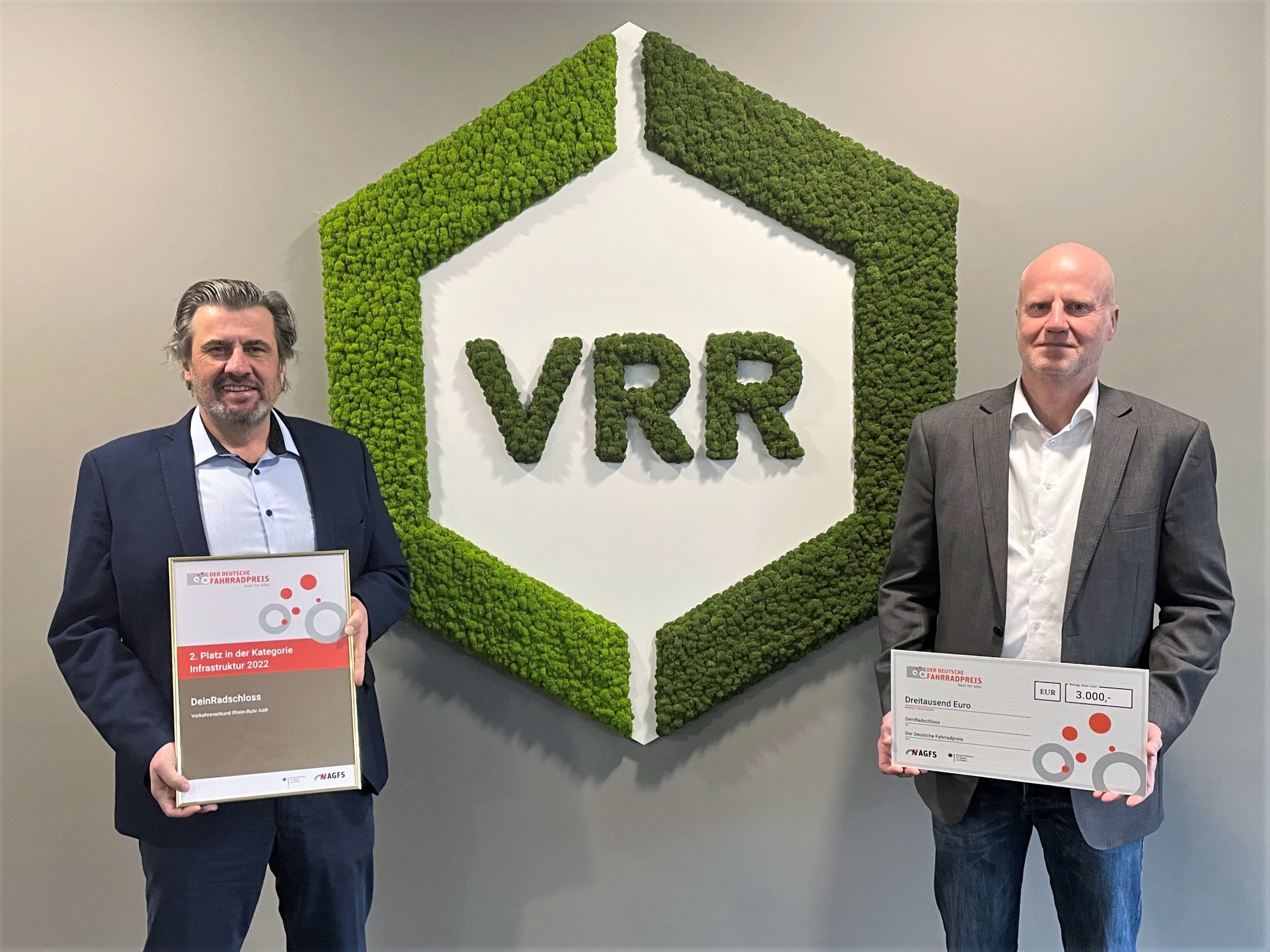 Micheael Zyweck und Rolf Ommen mit den Urkunden vor dem VRR-Logo