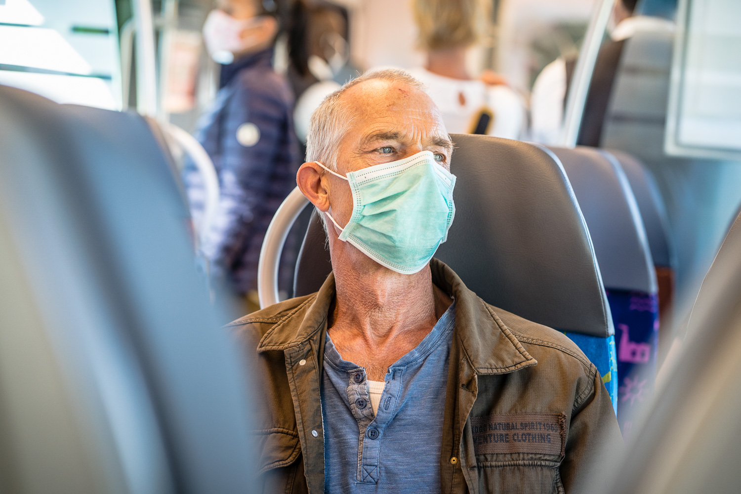 Ein Mann trägt Maske im Zug