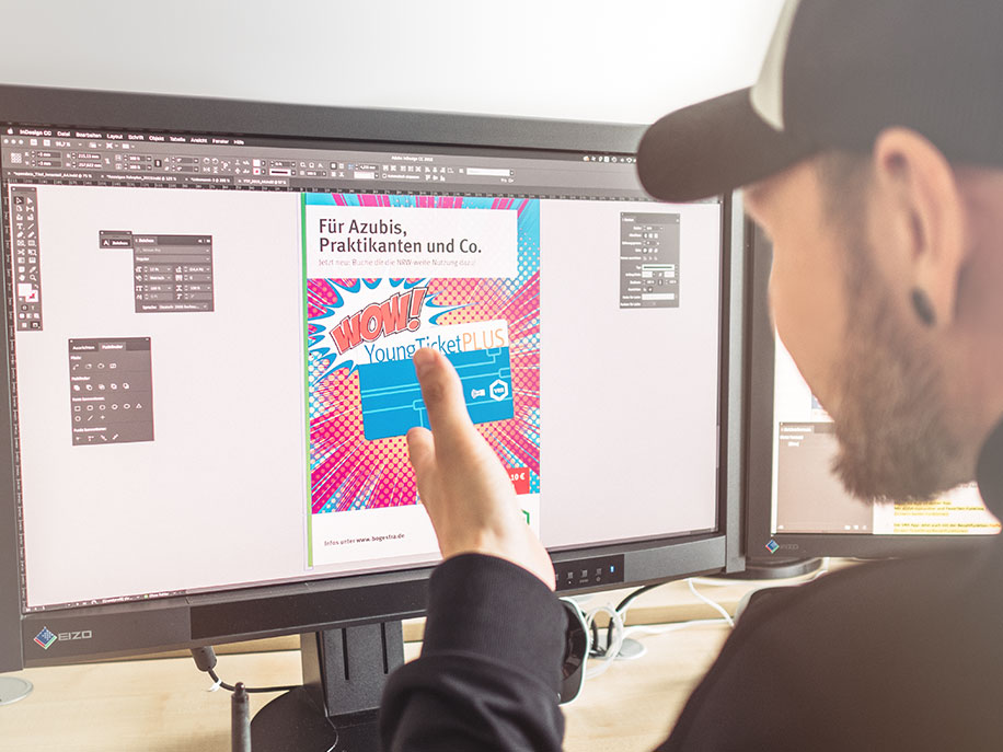 Ein Mitarbeiter der Grafikabteilung beim VRR gestaltet am PC einen Flyer für das Young Ticket Plus.