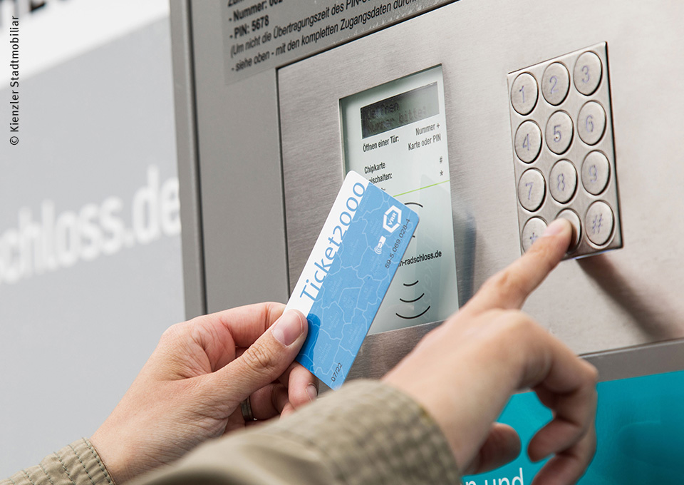 Jemand hält ein AboTicket vor den Automaten
