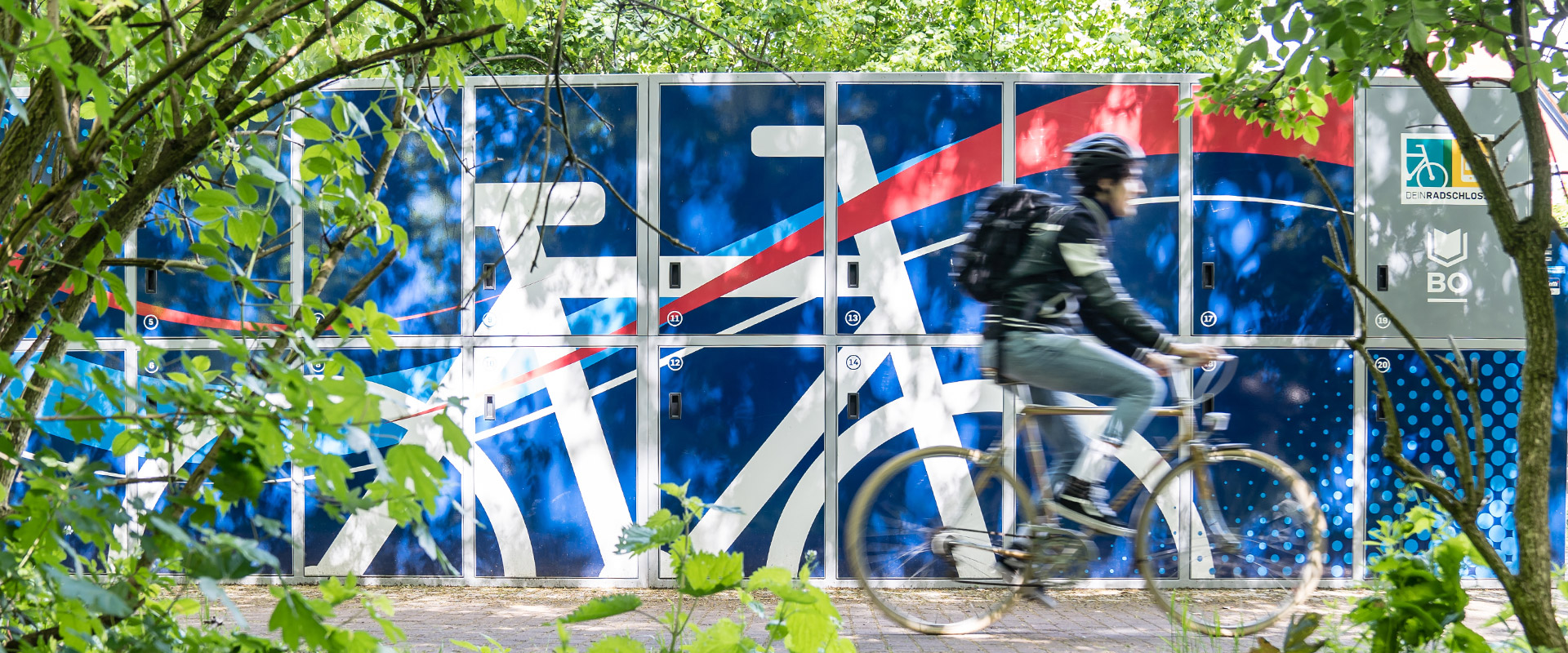 Fahrradfahrer fährt an den Fahrradboxen von Mein Radschloss vorbei