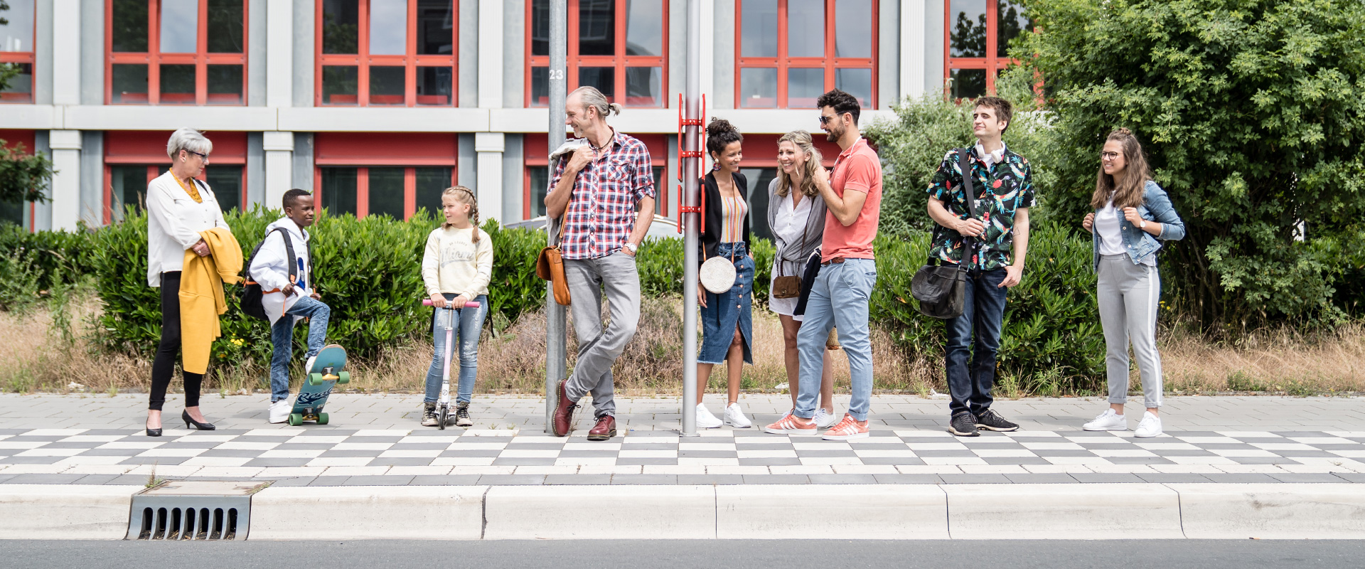 Mehrere Fahrgäste warten an einer Bushaltestelle