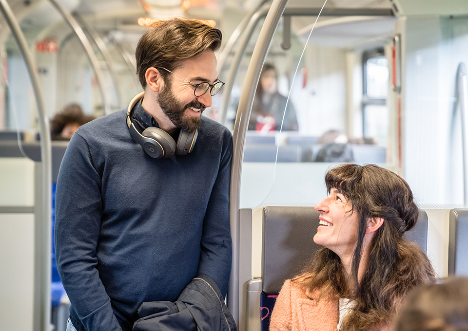 Zwei Fahrgäste unterhalten sich im Zug