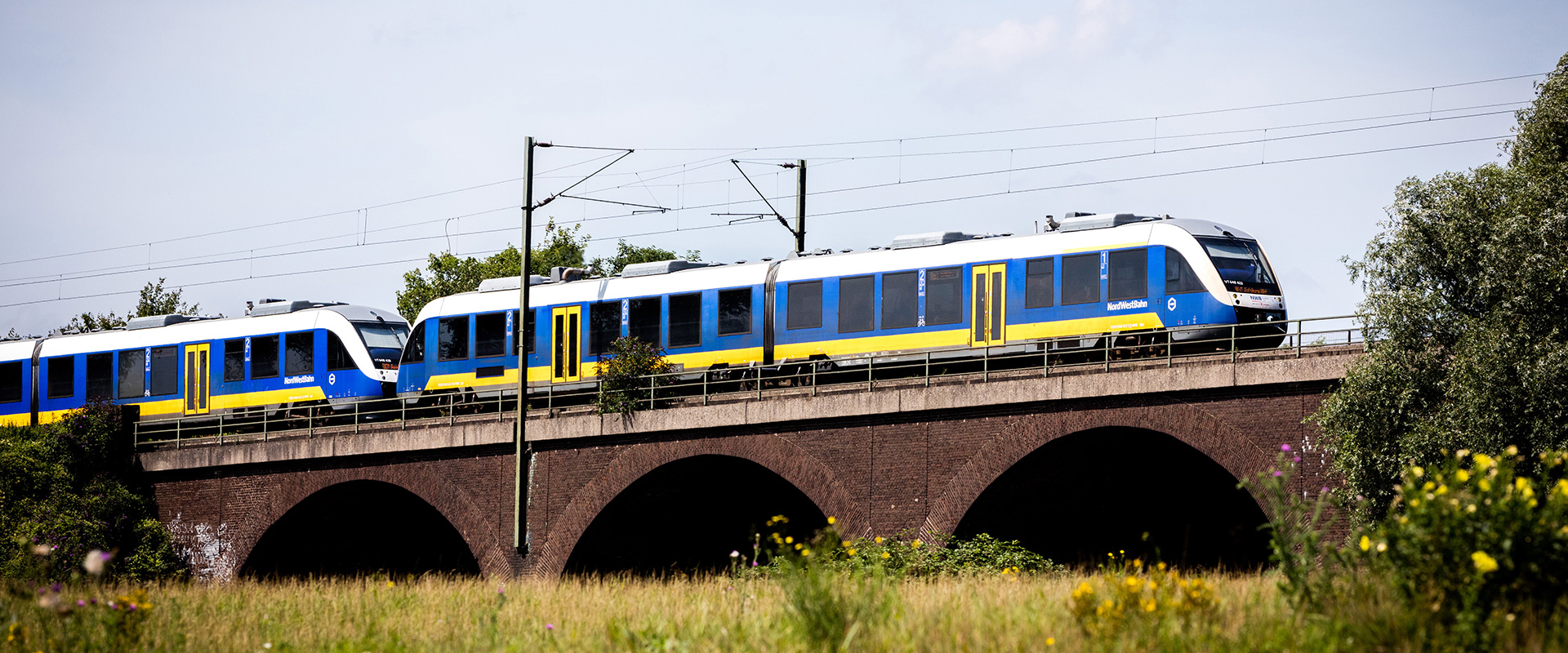 Ein Zug der Nordwestbahn fährt über eine Eisenbahnbrücke