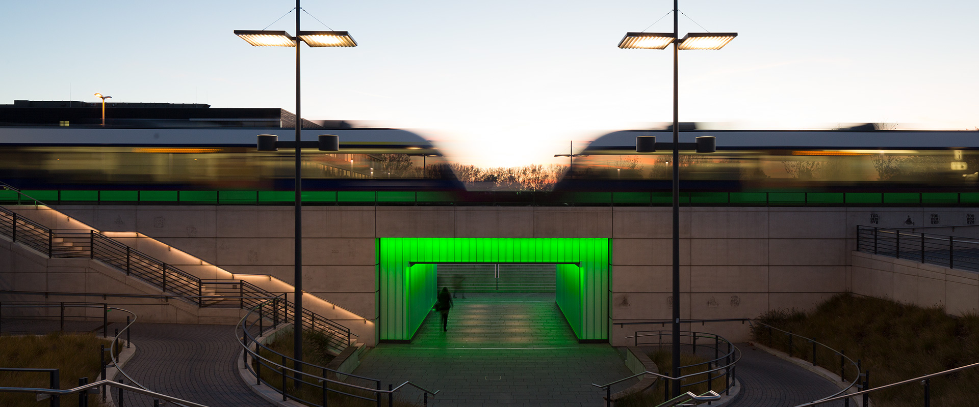 Grün illuminierte Fußgängerunterführung am Bahnhof