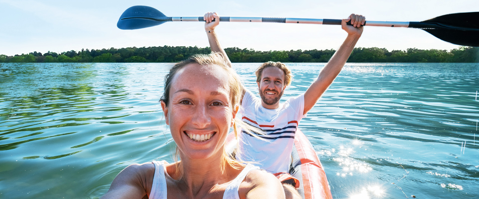 Eine junge Frau und ein junger Mann fahren in einem Kanu auf einem See