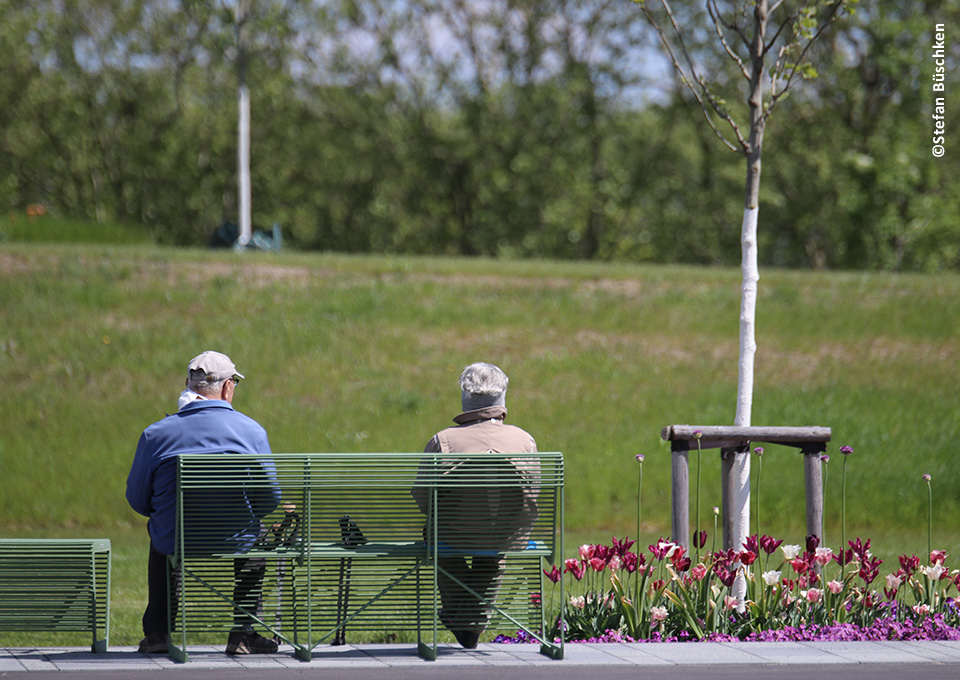 Mann und Frau sitzen auf einer Bank der Landesgartenschau