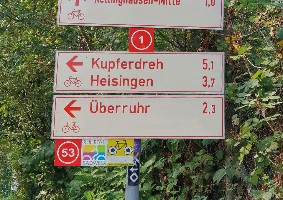 Pfeilwegweiser mit dem RuhrtalRadweg-Logo