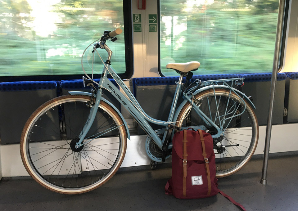 Ein blaues Fahrrad und ein Rucksack stehen in der S-Bahn