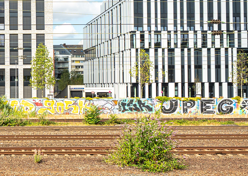 Eine Bahnstrecke entlang an Bürogebäuden