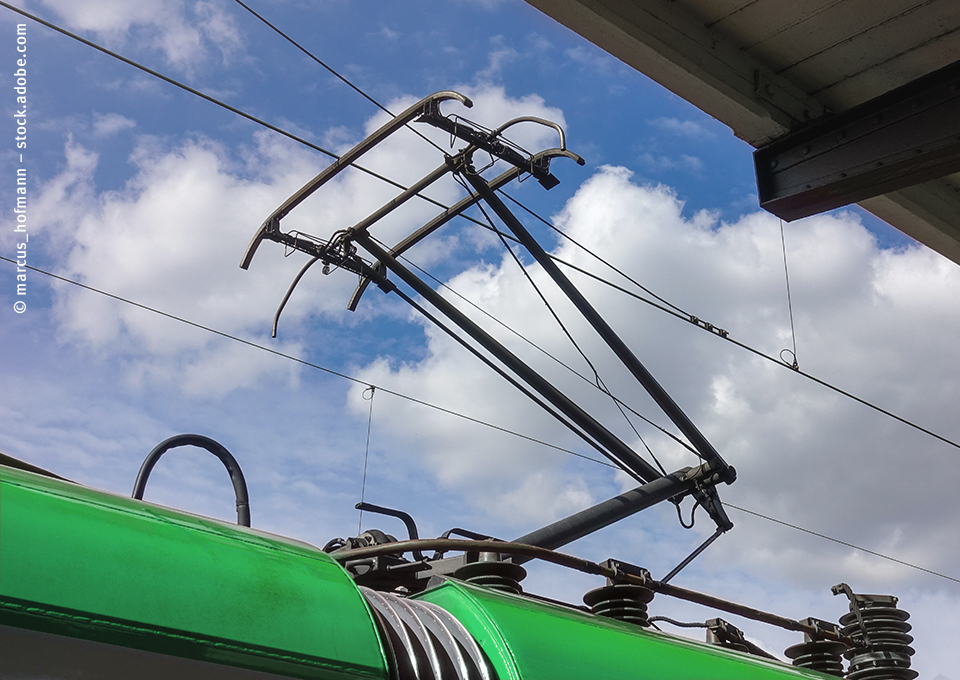 Stromabnehmer eines Zuges vor blauem Himmel mit weißen Wolken