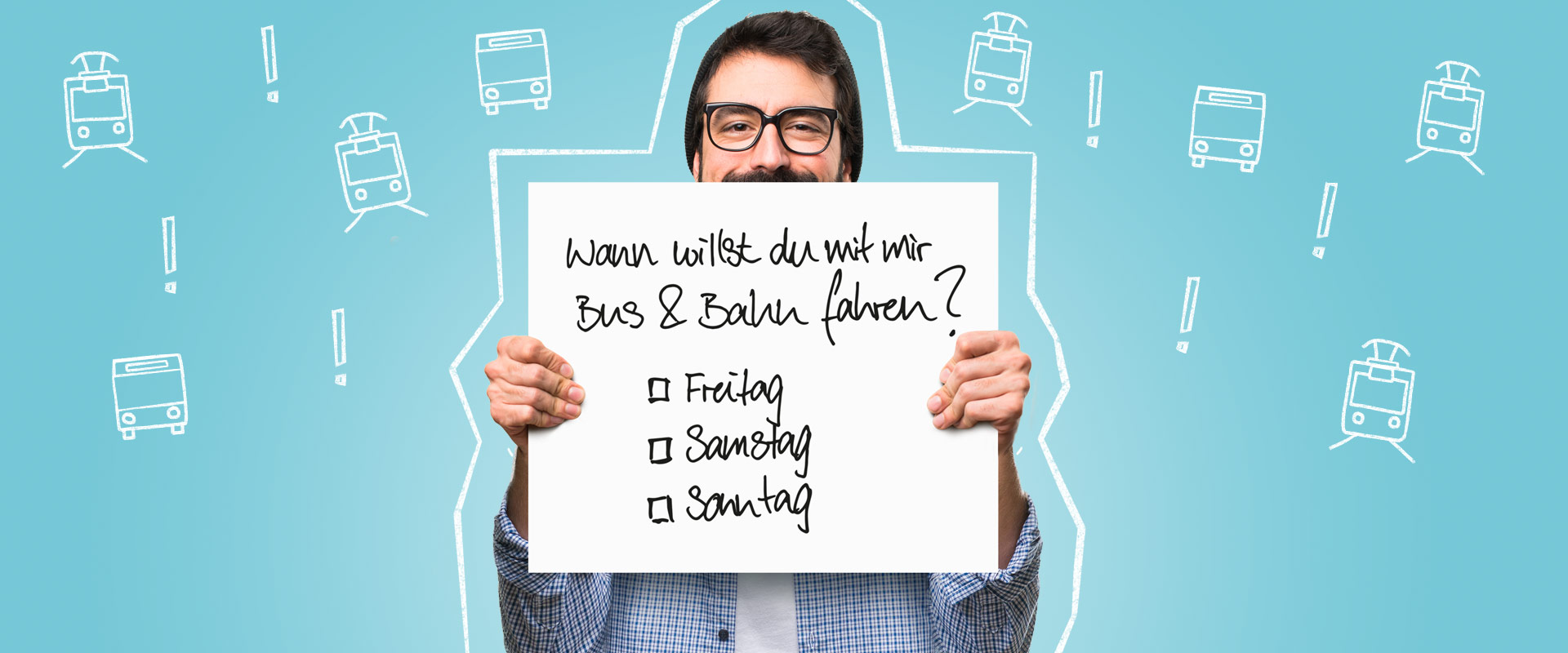 Ein Mann hält ein Schild mit der Frage "Willst du mit mir Bund und Bahn fahren? Freitag, Samstag, Sonntag?" hoch.